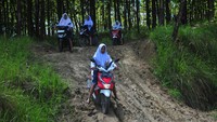 Pelajar mengendarai sepeda motor melintasi jalan tanah di kawasan hutan Dusun Kalitengah, Rejosari, Kradenan, Grobogan, Jawa Tengah, Selasa (7/3/2023).