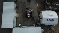 Makan bersama di pengungsian yang didirikan dari kontainer setelah gempa dahsyat mengguncang Nurdagi, Turki. Badan penanggulangan bencana Turki, AFAD mengatakan dua juta orang telah meninggalkan area terdampak gempa. Sebagian tinggal dengan teman atau orang-orang terdekat mereka di wilayah lain di negara ini.
