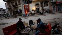 Mehmet Serkan Sincan, pemilik toko barang antik di Antakya tengah, dan temannya Ben Hur Side nongkrong di luar toko Sincan yang rusak setelah gempa mematikan, di Antakya, provinsi Hatay, Turki. Untuk menjaga rasa dalam keadaan normal, Serkan Sincan menggelar pameran di luar toko seperti dulu.  