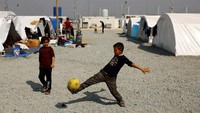 Abak-anak bermain bola di kamp yang sebagian besar dihuni oleh warga Suriah setelah gempa mematikan di Antakya. Setidaknya 1,5 juta orang kehilangan tempat tinggal dan terlunta-lunta. Belum jelas berapa lama lagi mereka bisa mendapatkan tempat berlindung yang layak.