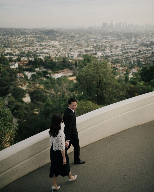 Kevin Sanjaya memilih gaya formal dengan setelan jas hitam yang dipadukan kemeja putih serta dasi dan sepatu pantofel. Gayanya semakin mengentalkan nuansa vintage a la Hollywood. Foto: Instagram/@valenciatanoe