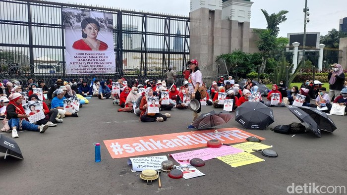 Sejumlah orang menggelar unjuk rasa mendesak pengesahan RUU PPRT di depan gedung DPR. Baliho bergambar wajah Ketua DPR Puan Maharani dibentangkan. (Ilham Oktafian/detikcom)