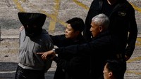 Usai ditangkap di China, wanita itu diserahkan kepada otoritas Hong Kong di Pelabuhan Teluk Shenzhen pada Selasa (7/3) waktu setempat. Tampak kepalaanya ditutup dengan kain hitam.