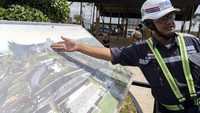 Seorang pekerja menunjukkkan gambaran desain IKN yang akan dibangun.