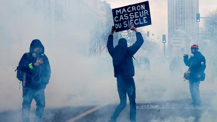 Protesters attend a demonstration against French governments pension reform plan in Paris, as part of the sixth day of national strike and protests, in France, March 7, 2023. The sign reads: 