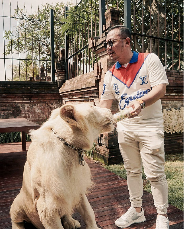 Di sebuah foto, ia terlihat berpose memberi minum seekor singa putih. Wahyu Kenzo tampak mengenakan kaus polo Louis Vuitton. Dalam situs resmi Louis Vuitton, kaus Equipe LV Polo itu dibanderol dengan harga US$ 1.150 atau sekitar Rp 17,8 juta. (Foto: Instagram)