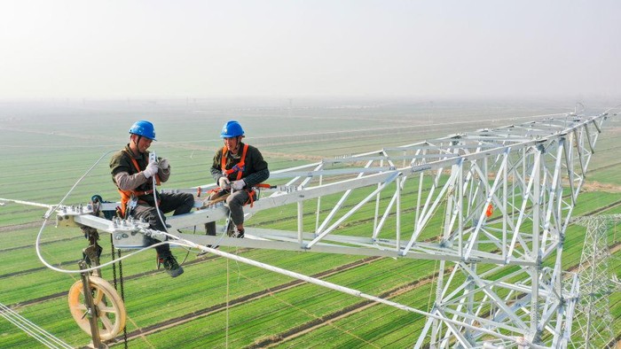 Aksi Teknisi di Atas Pembangkit Listrik Tenaga Nuklir Setinggi 70 Meter LIANYUNGANG, CHINA - MARCH 09: Employees of Jiangsu Power Transmission and Transformation Co., Ltd. work on a 70-meter-high transmission tower at Tianwan Nuclear Power Plant on March 9, 2023 in Lianyungang, Jiangsu Province of China. (Photo by Shi Jun/VCG via Getty Images)