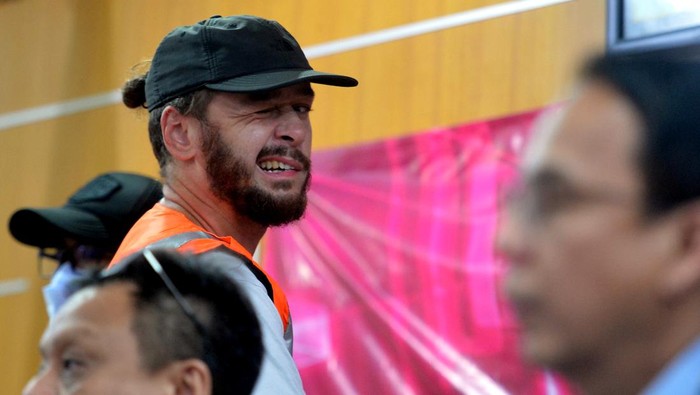 Warga negara Rusia berinisial SR yang akan dideportasi dihadirkan petugas saat konferensi pers di Kantor Imigrasi Kelas I TPI Denpasar, Bali, Rabu (8/3/2023). Imigrasi Bali mendeportasi SR karena menyalahgunakan izin tinggalnya dengan bekerja sebagai fotografer di Bali.
