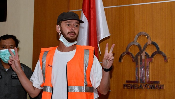 Warga negara Rusia berinisial SR yang akan dideportasi dihadirkan petugas saat konferensi pers di Kantor Imigrasi Kelas I TPI Denpasar, Bali, Rabu (8/3/2023). Imigrasi Bali mendeportasi SR karena menyalahgunakan izin tinggalnya dengan bekerja sebagai fotografer di Bali.