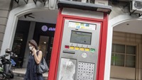 Warga melintas di samping mesin parkir elektronik di Jakarta, Kamis (09/03/2023).