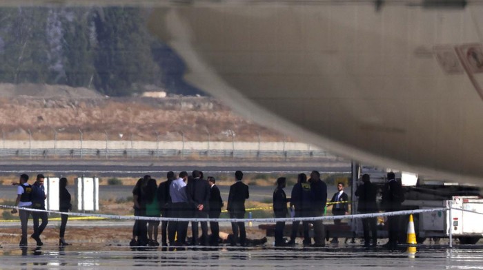 Perampok dan Polisi Baku Tembak di Bandara Santiago Investigation police officers inspect a body on Santiago de Chile Airport slab after a valuables truck attempted robbery left two people dead in the midst of an intense firefight, police and local media reported, in Santiago, Chile, March 8, 2023. REUTERS/Ivan Alvarado