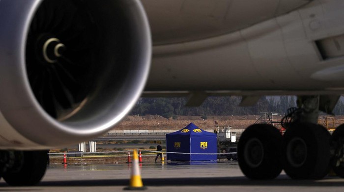 Perampok dan Polisi Baku Tembak di Bandara Santiago Investigation police officers inspect a body on Santiago de Chile Airport slab after a valuables truck attempted robbery left two people dead in the midst of an intense firefight, police and local media reported, in Santiago, Chile, March 8, 2023. REUTERS/Ivan Alvarado