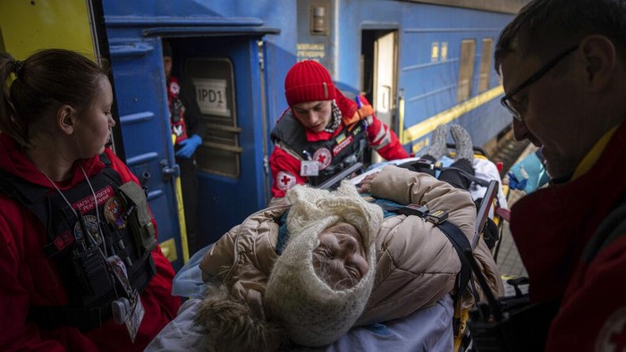 Potret Kereta Medis Ukraina Evakuasi Pasien di Zona Perang MSF workers carry a man on a stretcher into a MSF medical train that evacuates patients from near the frontline of the fighting to safer areas, at the train station in Pokrovsk, Ukraine, Tuesday, March 7, 2023. (AP Photo/Evgeniy Maloletka)