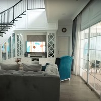 Di sebelah ruang tamu terdapat ruang keluarga yang tak kalah nyaman. Ruang keluarganya itu dilengkapai dengan sebuah sofa panjang berwarna abu-abu, sofa kecil berwarna hijau, dan televisi. Foto: YouTube/AH