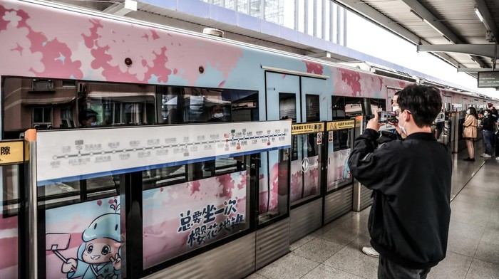 Sambut Musim Semi, Kereta Bawah Tanah di Wuhan Bertema Sakura WUHAN, CHINA - MARCH 08: Passengers ride a themed subway train with patterns of cherry blossom on March 8, 2023 in Wuhan, Hubei Province of China. With interior and exterior decorated with cherry blossom images, the themed train with operate until April 30. (Photo by VCG/VCG via Getty Images)