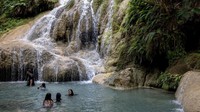 Orang-orang berkumpul di tepi air terjun di Taman Nasional Erawan, Kanchanaburi, Thailand.