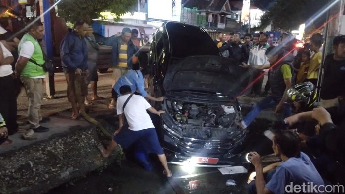 Mobil dinas milik Pemprov Gorontalo terperosok di drainase.