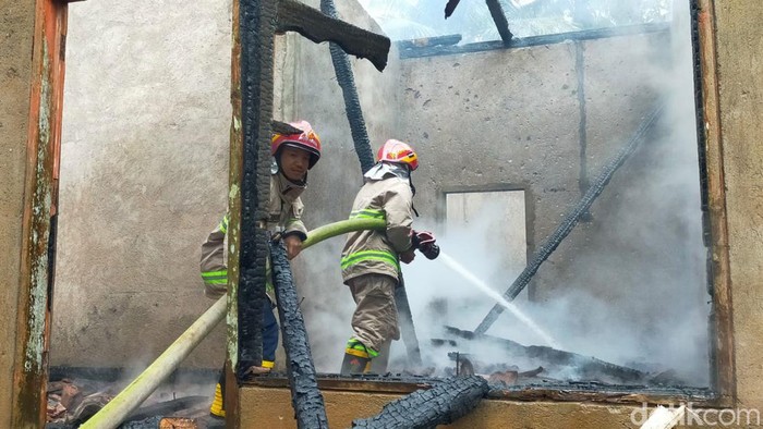 Petugas memadamkan rumah warga di Blitar yang dibakar pria ODGJ