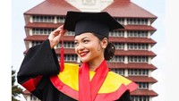 Pose Amel Carla lengkap memakai toga dengan latar belakang Gedung Rektorat UI Foto: dok. Instagram Amel Carla