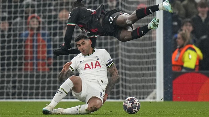 Tottenhams Cristian Romero, bottom, fouls AC Milans Rafael Leao during the Champions League round of 16 second leg soccer match between Tottenham Hotspur and AC Milan at the Tottenham Hotspur stadium in London, Wednesday, March 8, 2023. (AP Photo/Alastair Grant)