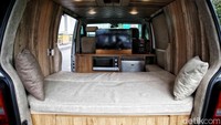 Tampak sebuah campervan dilengkapi ranjang, tv, oven, hingga kulkas.