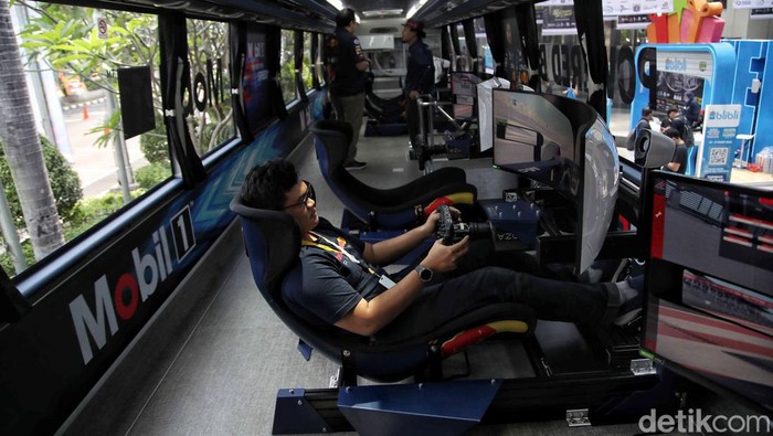 Sejumlah pengunjung mencoba simulator mobil Formula 1 di Jakarta Auto Week 2023, JCC Senayan, Sabtu (11/3/2023).