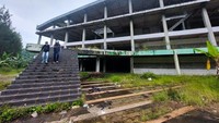 Dua pengunjung menjelajahi bangunan Convention Hall dan kafetaria Kampung Gajah yang rusak usai tutup pada 2018 lalu