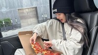 Ketika menempuh perjalanan panjang, makanan enak harus ada di mobilnya. Seperti pizza dengan ukuran besar yang disantapnya dengan ceria. Foto: Instagram/lalalalisa_m