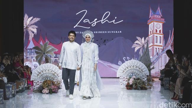 Pasangan selebriti Dimas Seto dan Dhini Aminarti berjalan sambil berpegangan tangan membawakan koleksi Zashi. Foto: Grandyos Zafna.