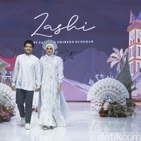 Pasangan selebriti Dimas Seto dan Dhini Aminarti berjalan sambil berpegangan tangan membawakan koleksi Zashi. Foto: Grandyos Zafna.