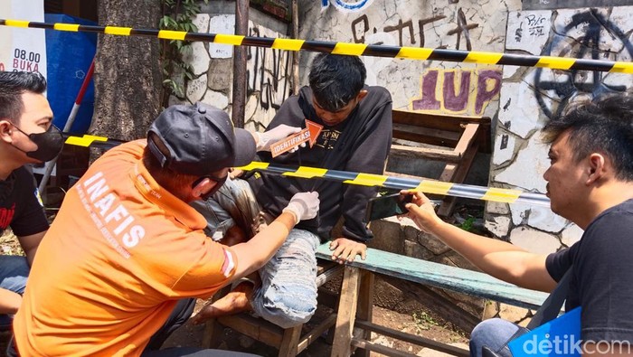 Temuan mayat laki-laki berlumur darah terduduk di pinggir jalan.