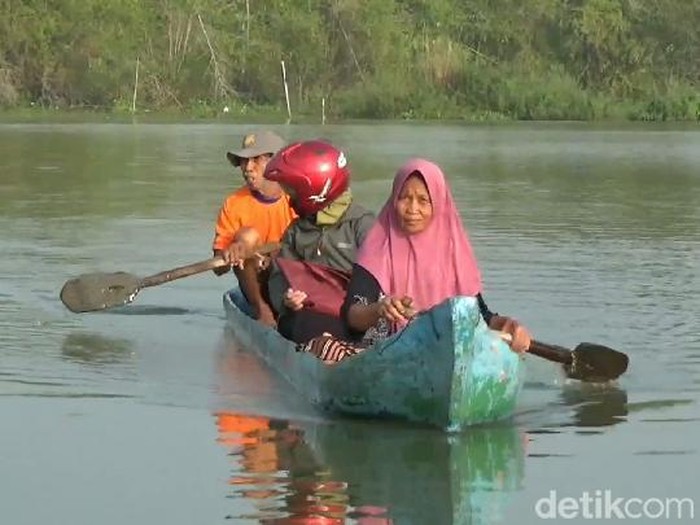 Warga di Desa Banjarsari, Kecamatan Gabus, Pati, beraktivitas menggunakan perahu karena banjir, Sabtu (11/3/2023).
