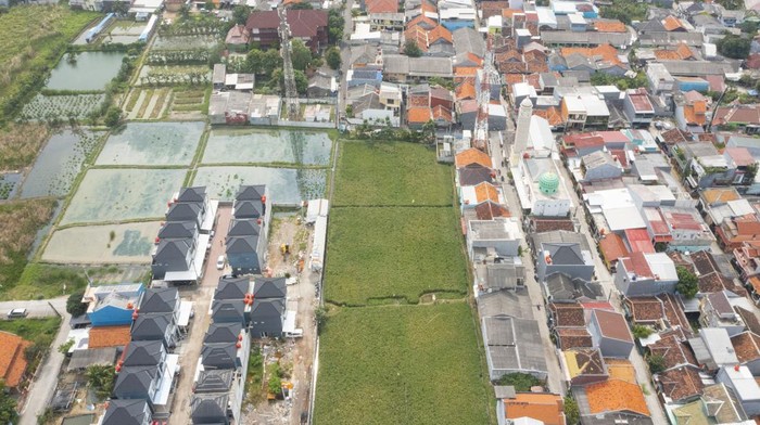 Foto udara areal persawahan di tengah permukiman padat penduduk di kawasan Rorotan, Jakarta Utara, Minggu (12/3/2023). Kementerian Pertanian mencatat, alih fungsi lahan pertanian mencapai 90 ribu hingga 100 ribu hektare per tahun, konversi lahan tersebut menjadi salah satu ancaman bagi sektor pertanian dalam upaya meningkatkan produksi untuk memenuhi kebutuhan masyarakat. ANTARA FOTO/M Risyal Hidayat/rwa.