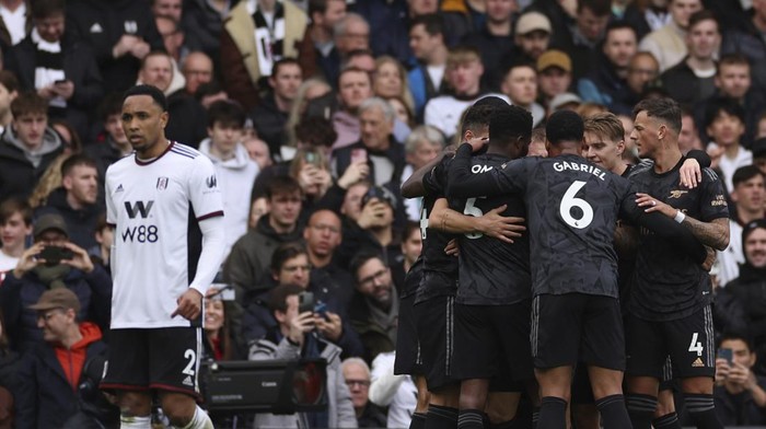 Arsenal players celebrate after Fulhams Antonee Robinson scoring an own disallowed goal past his goalkeeper during the English Premier League soccer match between Fulham and Arsenal at Craven Cottage stadium in London, Sunday, March 12, 2023. (AP Photo/Ian Walton)