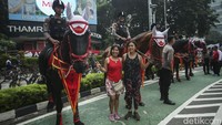 Kehadiran polisi berkuda di Bundaran HI menjadi perhatian warga. 