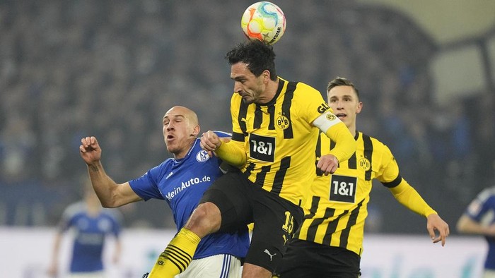 Schalkes Michael Frey, left, and Dortmunds Mats Hummels challenge for the ball during the German Bundesliga soccer match between FC Schalke 04 and Borussia Dortmund in Gelsenkirchen, Germany, Saturday, March 11, 2023. (AP Photo/Martin Meissner)