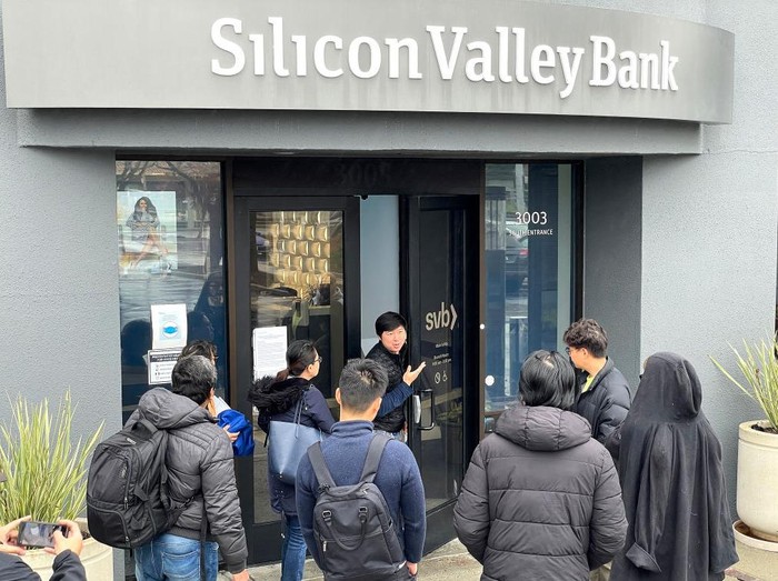 SANTA CLARA, CALIFORNIA - MARCH 10: A worker (C) tells people that the Silicon Valley Bank (SVB) headquarters is closed on March 10, 2023 in Santa Clara, California. Silicon Valley Bank was shut down on Friday morning by California regulators and was put in control of the U.S. Federal Deposit Insurance Corporation. Prior to being shut down by regulators, shares of SVB were halted Friday morning after falling more than 60% in premarket trading following a 60% declined on Thursday when the bank sold off a portfolio of US Treasuries and $1.75 billion in shares to cover  declining customer deposits. (Photo by Justin Sullivan/Getty Images)