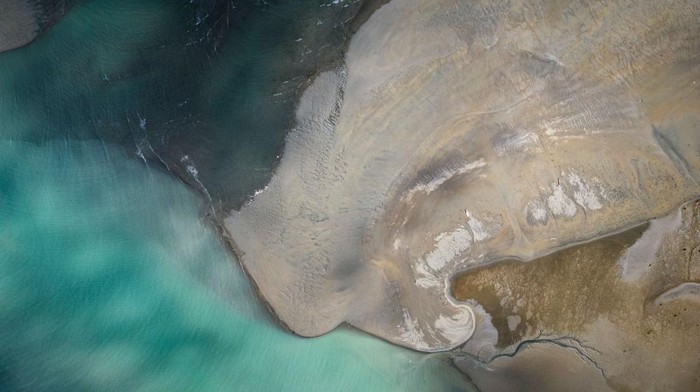 POLA, PHILIPPINES - MARCH 08: An aerial view shows oil slick from the sunken tanker MT Princess Empress along a shoreline on March 08, 2023 in Pola, Oriental Mindoro, Philippines. Authorities are racing to contain an oil spill after an oil tanker sunk off the coast of Oriental Mindoro, south of Manila. The tanker, MT Princess Empress, was carrying 800,000 liters of industrial oil when it sank on February 28 due to engine trouble and rough seas. Marine experts estimate that about 36,000 hectares of coral reefs, mangroves, and seagrass are in danger of being damaged. The spill has also prompted authorities to ban fishing and swimming in contaminated waters, halting the livelihood of countless residents who rely on fishing and tourism to survive. (Photo by Ezra Acayan/Getty Images)