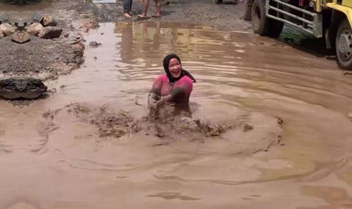 Aksi warga mandi di kubangan lumpur jalan rusak (Foto: Istimewa)