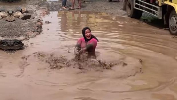 Aksi warga mandi di kubangan lumpur jalan rusak (Foto: Istimewa)