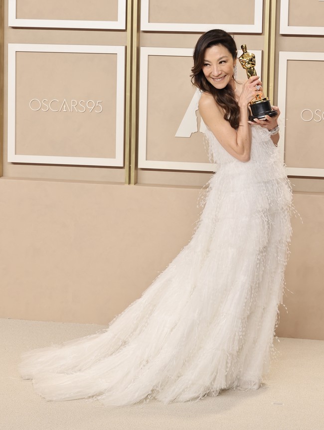 Saat menyampaikan pidato kemenangannya, Michelle Yeoh juga mendedikasikan pialanya untuk sang ibu. Mereka (ibu) benar-benar pahlawan super, dan tanpa mereka, tidak seorang pun dari kita akan berada di sini malam ini,” katanya. Foto: Rodin Banica/WWD via Getty Images