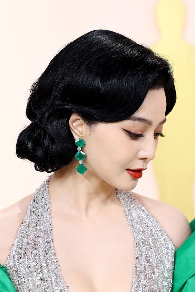 Sepasang anting chandelier hijau Emerald melengkapi penampilannya yang super megah dan mewah. Foto: Getty Images
