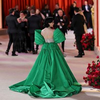 Jubah hijau dengan detail pleats dan ekor panjang menyapu lantai membuat gayanya semakin dramatis. Foto: Getty Images