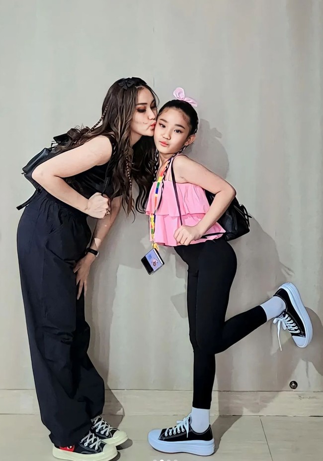 Kompak mengenakan sneakers, Ayu dan Bilqis tampil sporty. Pasangan ibu dan anak itu tampak kompak nonton konser bersama. Foto: Instagram/@ayutingting92