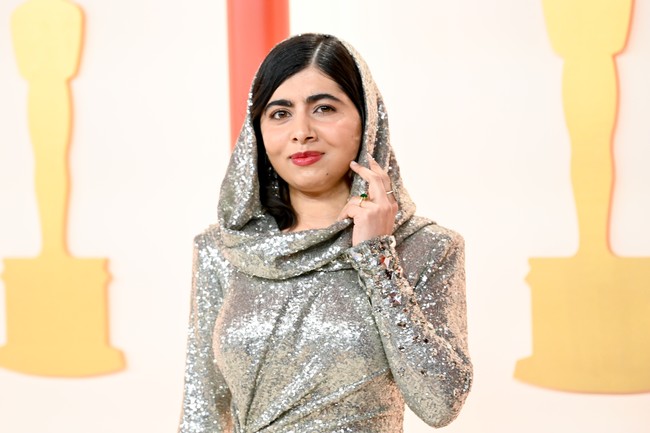Malala yang biasa tampil berkerudung juga terakomodasi gayanya berkat fitur hoodie yang menyatu dengan gaun tersebut. (Foto: Gilbert Flores/Variety via Getty Images)