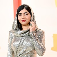 Malala yang biasa tampil berkerudung juga terakomodasi gayanya berkat fitur hoodie yang menyatu dengan gaun tersebut. (Foto: Gilbert Flores/Variety via Getty Images)