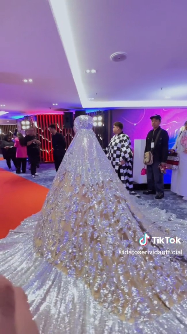 Dalam unggahannya di TikTok, wanita bernama lengkap Hasmiza Othman ini menjelaskan jika ia duduk di kursi paling belakang. Ia juga akan pulang paling awal karena ukuran mukenanya yang jumbo. Foto: Dok. TikTok @datoserividaofficial.