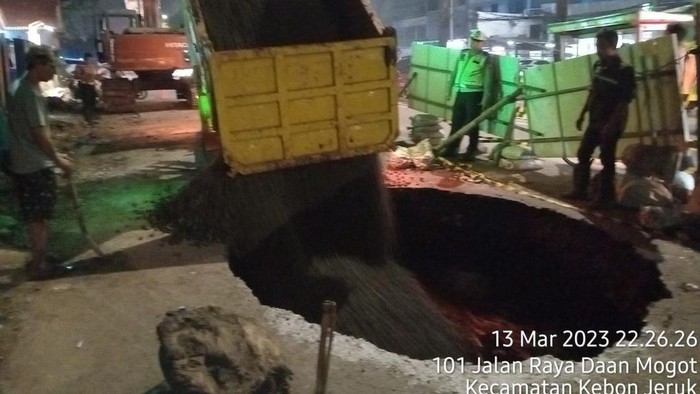 Lubang besar di Jalan Daann Mogot mulai diuruk.