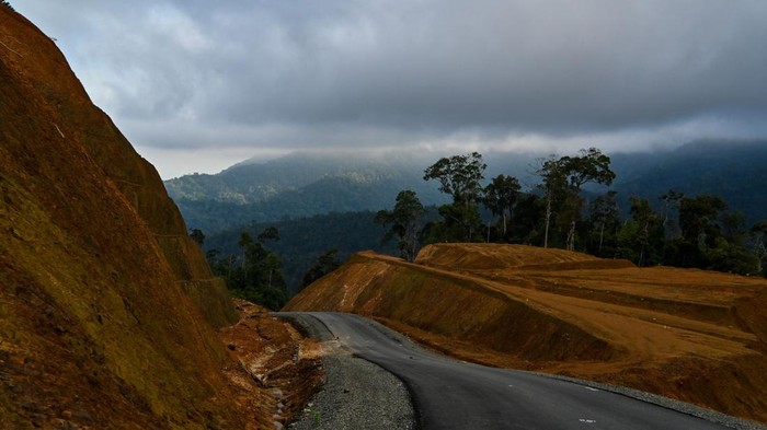 A motorist rides a newly constructed road seen on a mountain top in a protected forest are in Jantho, in Indonesia's Aceh province on March 12, 2023 (Photo by CHAIDEER MAHYUDDIN / AFP) (Photo by CHAIDEER MAHYUDDIN/AFP via Getty Images)
