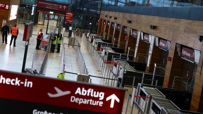 Pekerja Mogok Kerja, Begini Suasana di Bandara Berlin People walk near a departures board, as airport workers protest at BER airport during a strike called by German trade union Verdi, in Berlin, Germany, March 13, 2023. REUTERS/Christian Mang